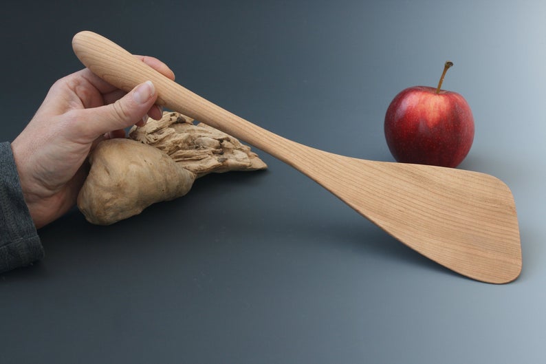 Black cherry wood wok spatula with large blade.