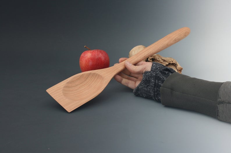 Cherry wood roux spoon with straight edge and handle.