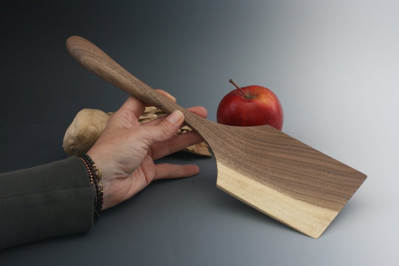 Large blade rectangular walnut wood spatula with curved handle.
