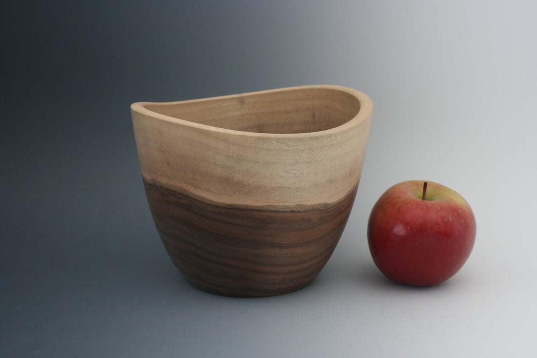 Walnut wood vessel shaped live edge bowl.