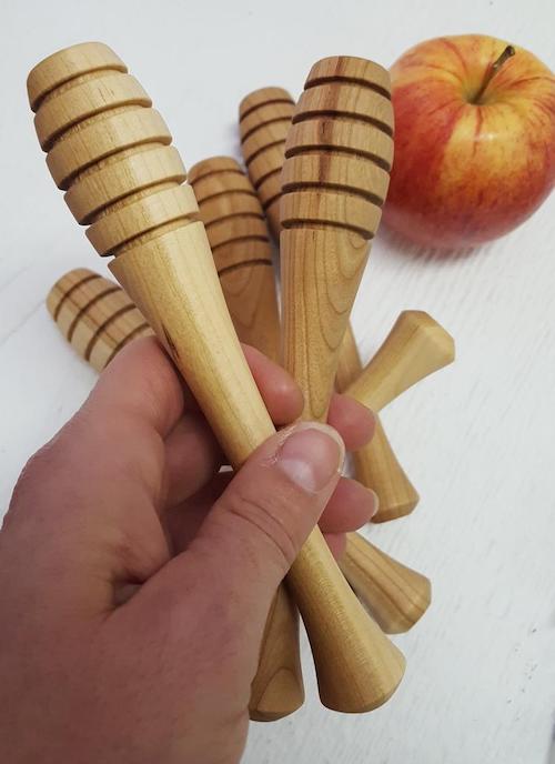 Handmade wooden honey dipper with grooves.